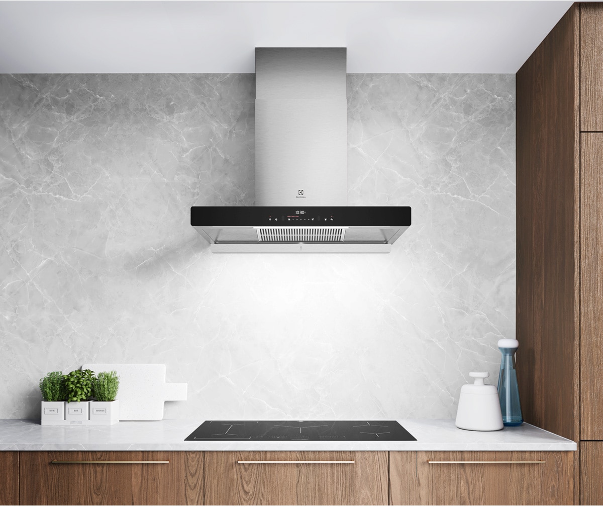 Electrolux stainless-steel chimney hood with black glass touch controls mounted above an induction hob