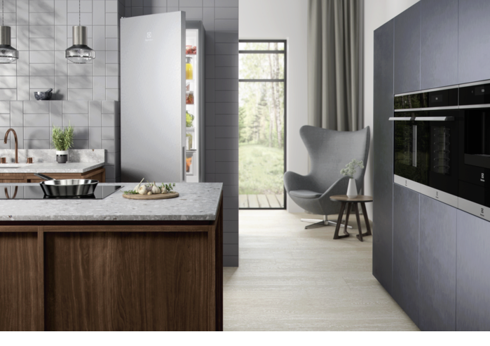 Modern kitchen with built-in ovens and an open fridge.