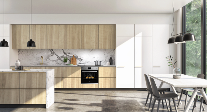Bright kitchen with built-in oven and two-toned cabinets.