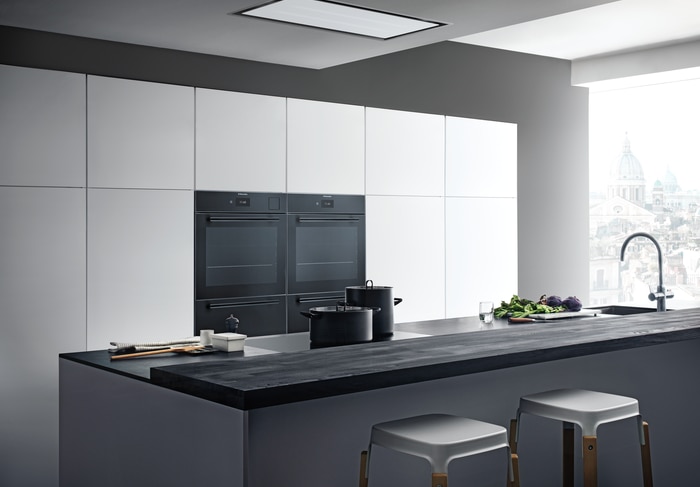 Sleek kitchen with integrated double ovens and a built-in cooktop.