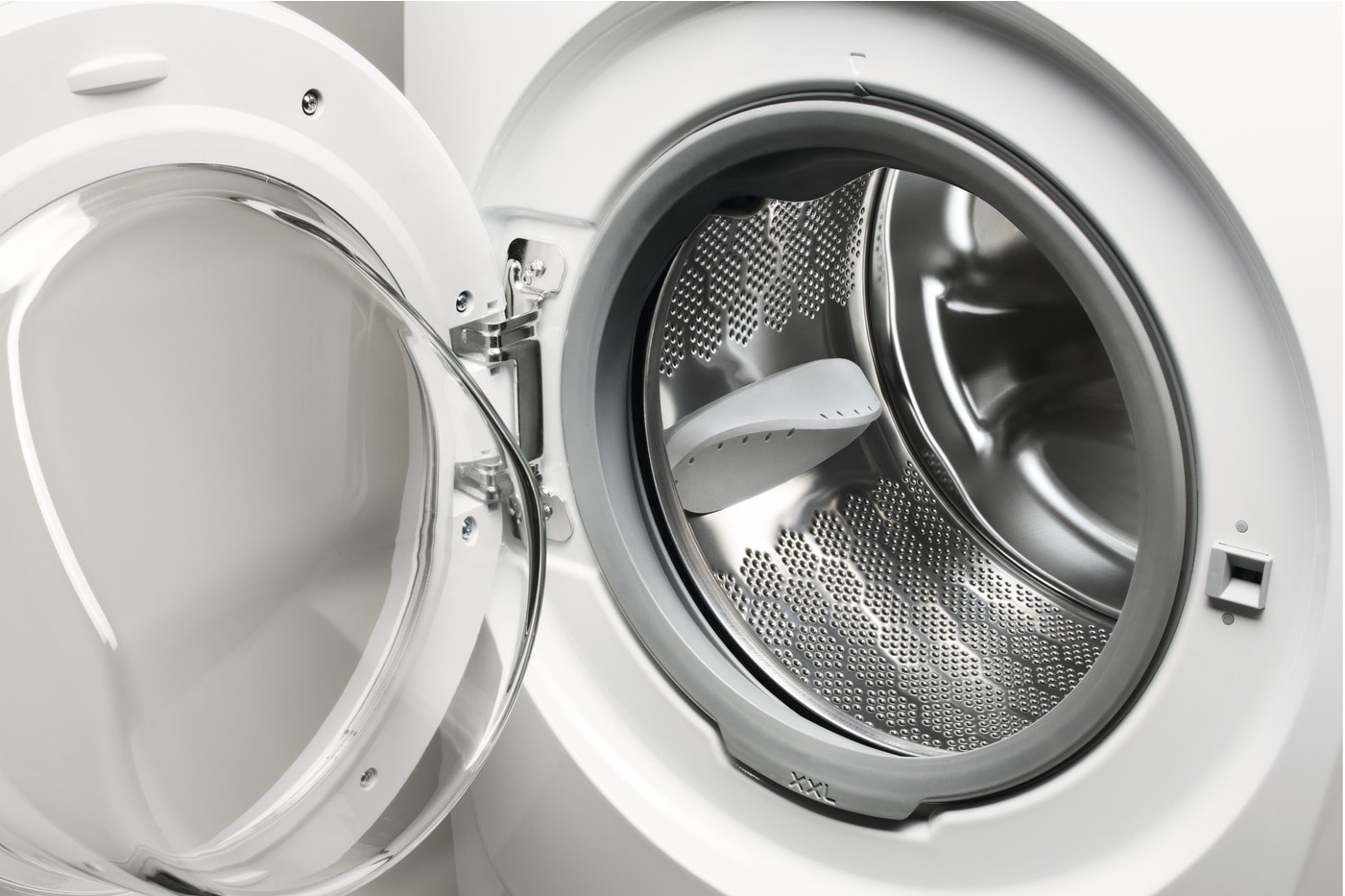 An open washing machine door airing out the interior drum to prevent moisture and bacterial buildup