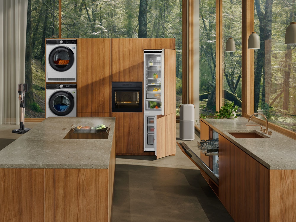 Home appliances combo featuring an Electrolux washer and dryer stack, built-in oven, refrigerator and dishwasher in an open-plan kitchen