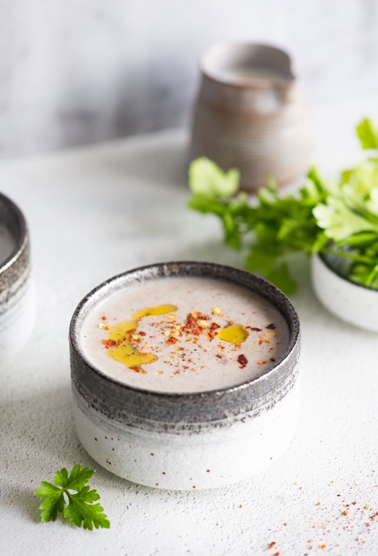 Creamy raita in a stoneware cup drizzled